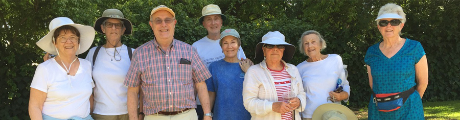 a group of older adults smiling with trees in the background