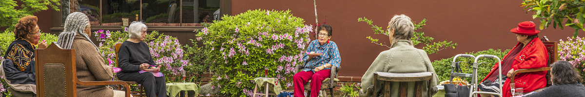a group of older women sitting outside in yard